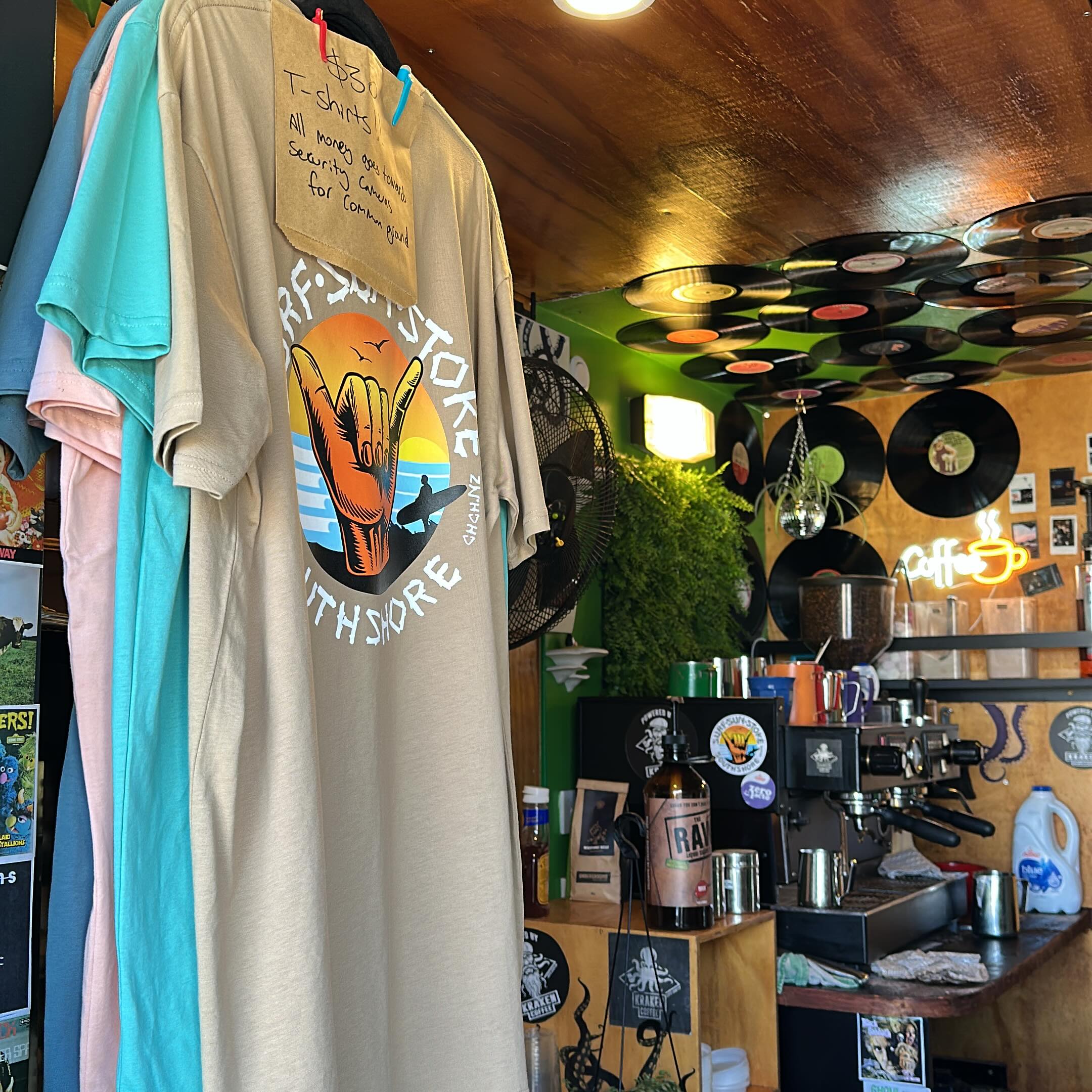 Inside the stand with merch and the neon coffee sign